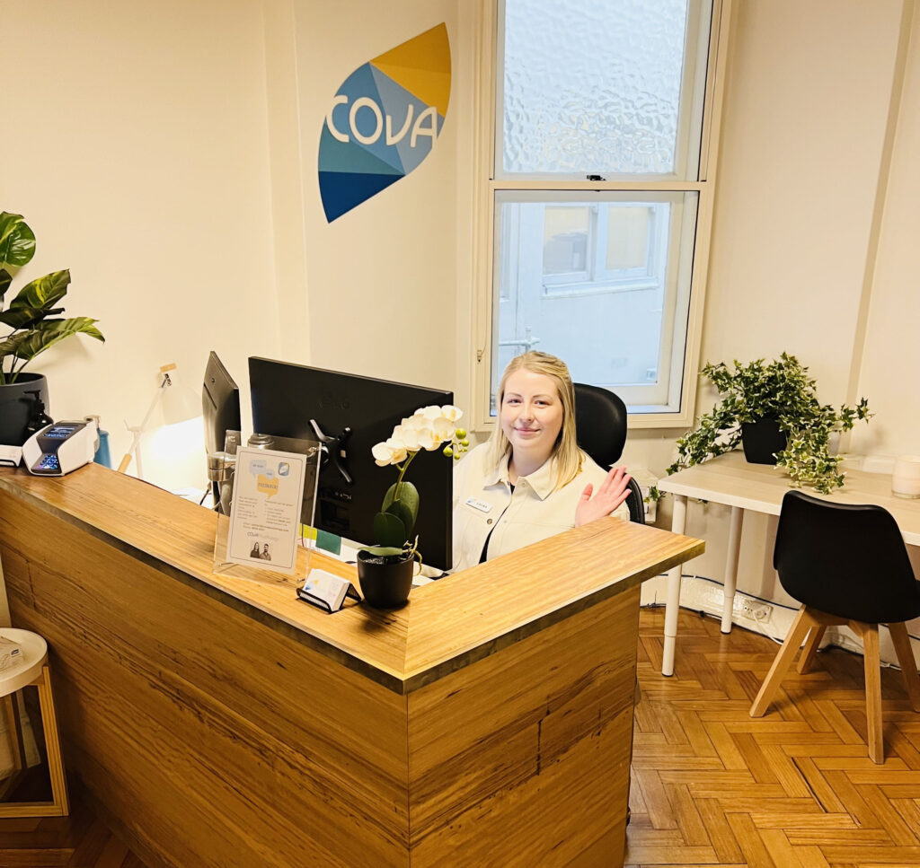 Friendly receptionist at Cova Psychology in Melbourne, welcoming clients to psychologist services.