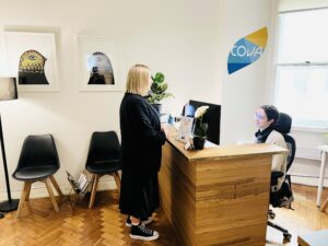 Receptionist welcoming a client at Cova Psychology's Melbourne clinic.